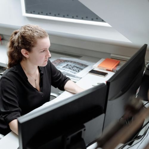 Colaboradora Usando Computador com 2 monitores